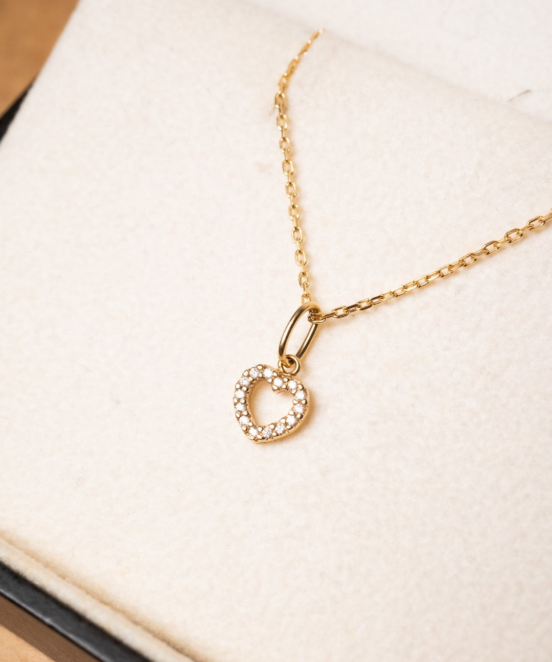 Pingente mini coração de ouro amarelo com diamantes. Mede 1.2cm por 0.6cm e pesa 0.5g.