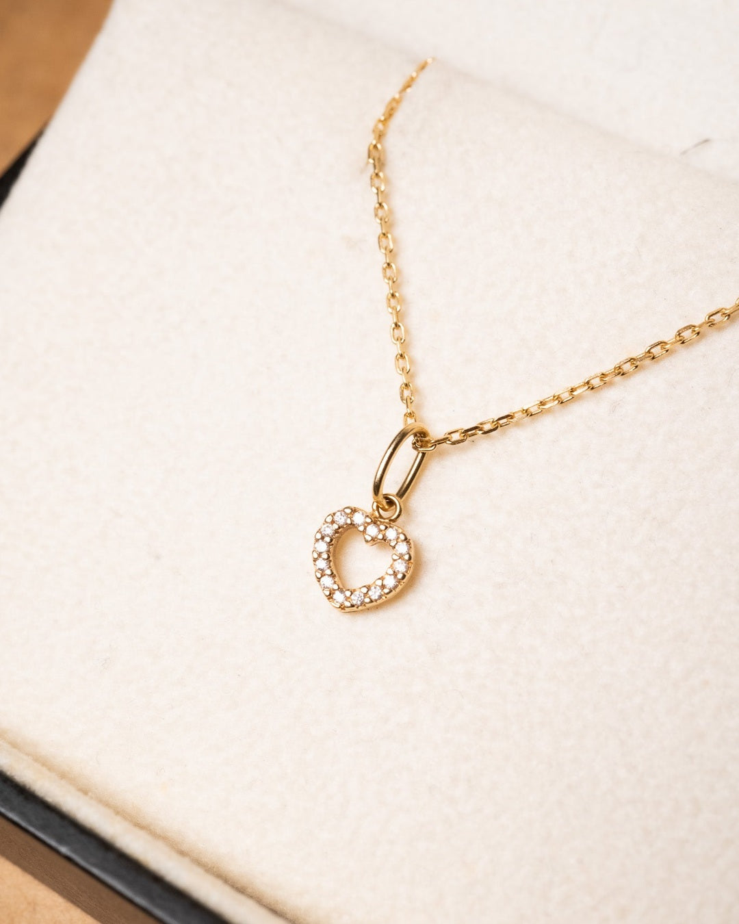 Pingente mini coração de ouro amarelo com diamantes. Mede 1.2cm por 0.6cm e pesa 0.5g.