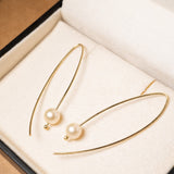 Brincos gancho de ouro amarelo com pérolas douradas de 0.7cm. Comprimento 5.0cm e peso 2.3g.