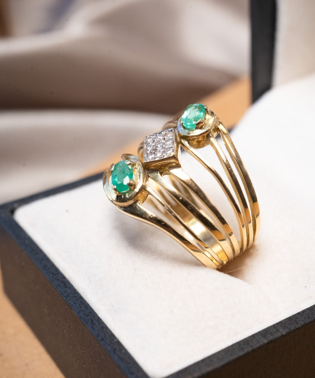 Anel bold em ouro amarelo com esmeraldas ovais de 0.3ct e safiras brancas de 0.02ct.