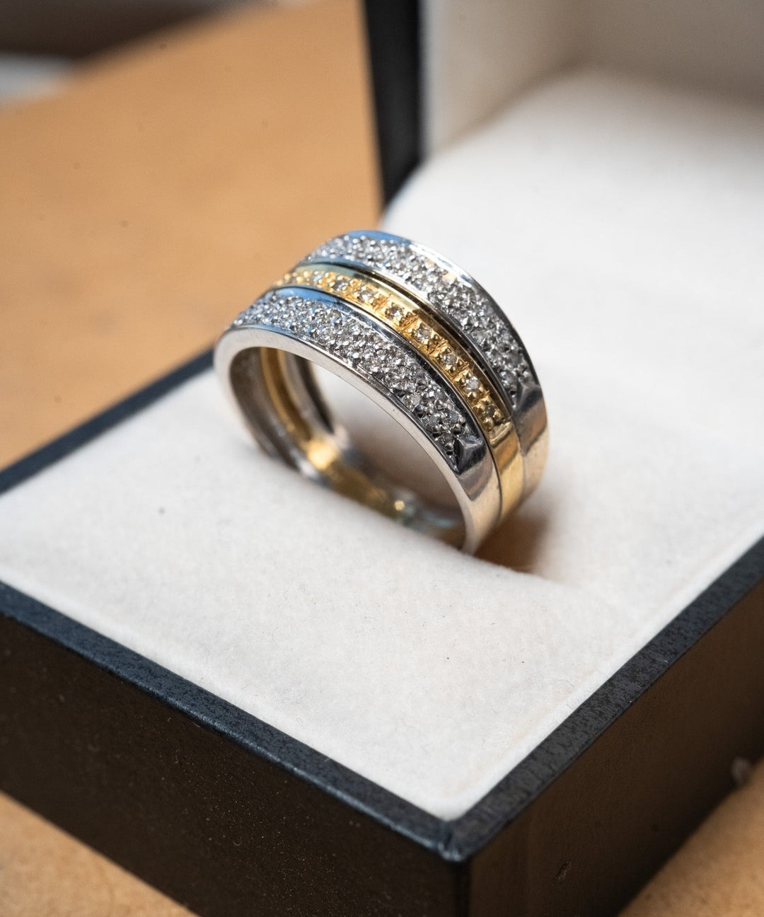 Anel pavê em ouro branco e amarelo com diamantes de 0.02 pontos. Peso 6.8g. Aro 23.