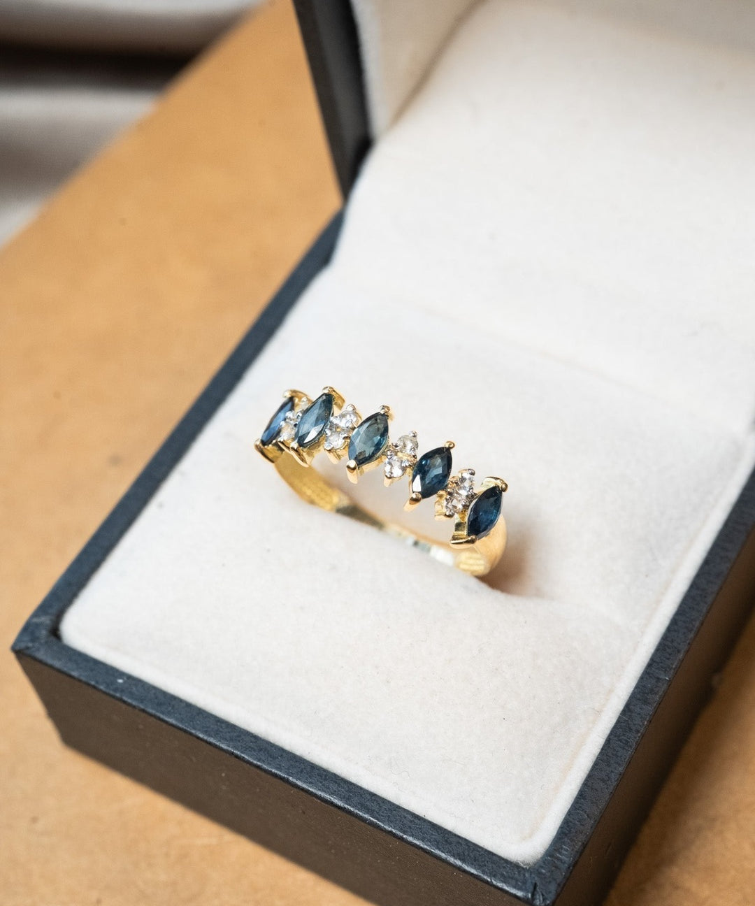 Anel meia aliança em ouro amarelo com safiras azuis navette de 0.15ct e diamantes brilhantes de 0.04ct.