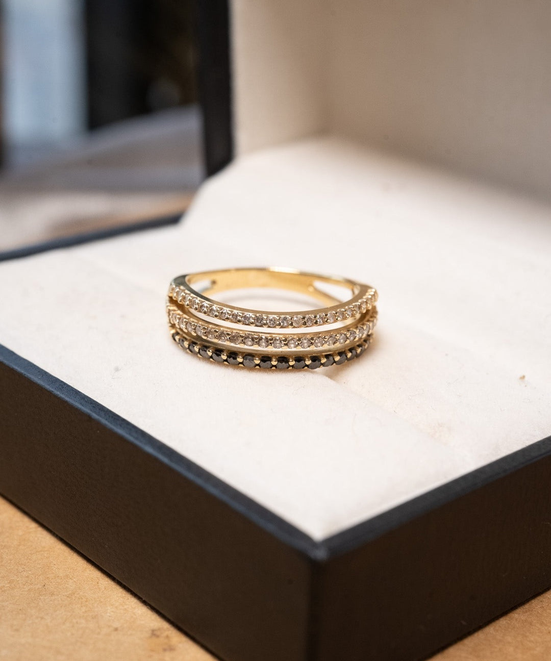 Anel meia aliança tripla em ouro amarelo com 17 diamantes negros e 45 diamantes brancos totalizando 0.79 quilates.