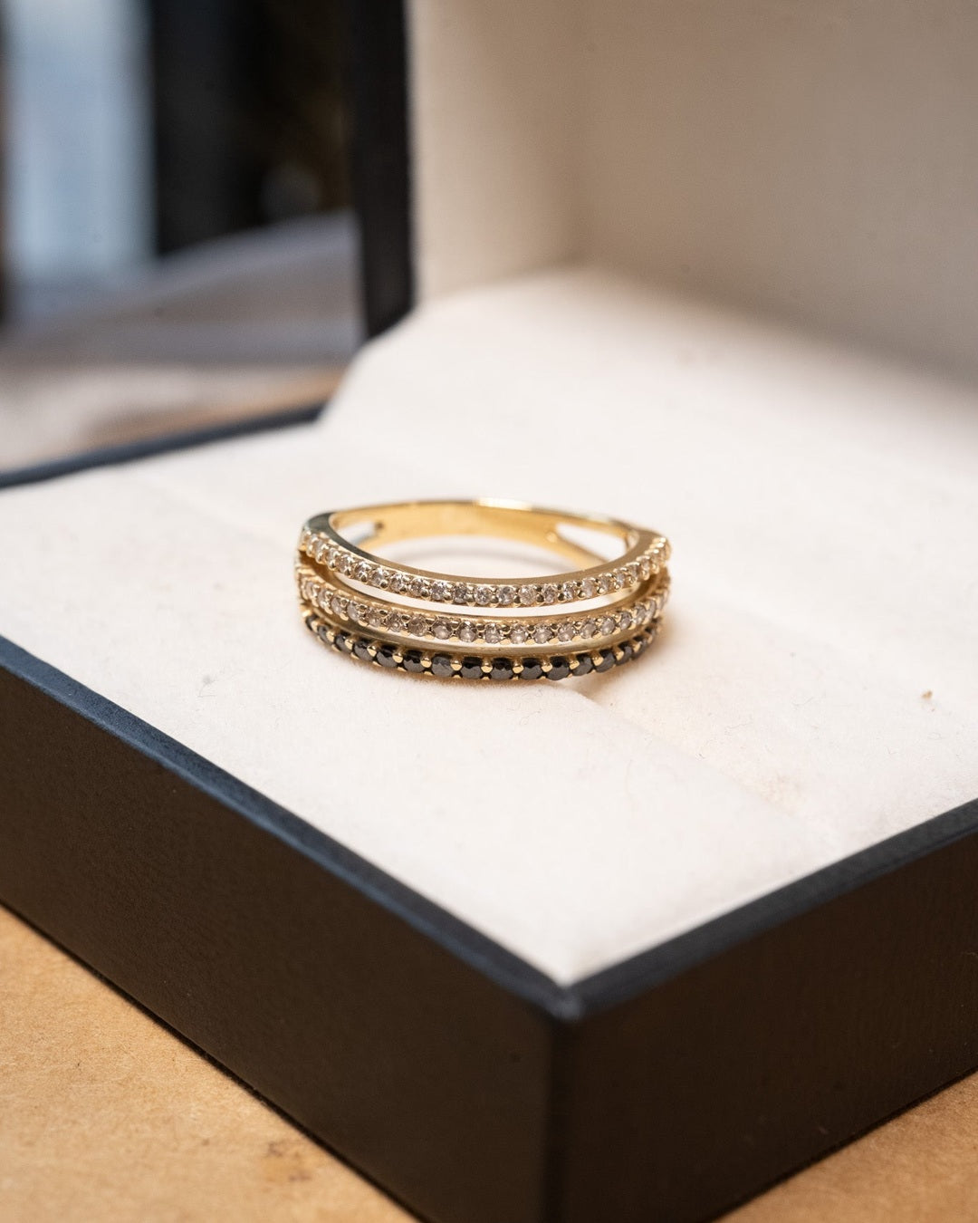 Anel meia aliança tripla em ouro amarelo com 17 diamantes negros e 45 diamantes brancos totalizando 0.79 quilates.