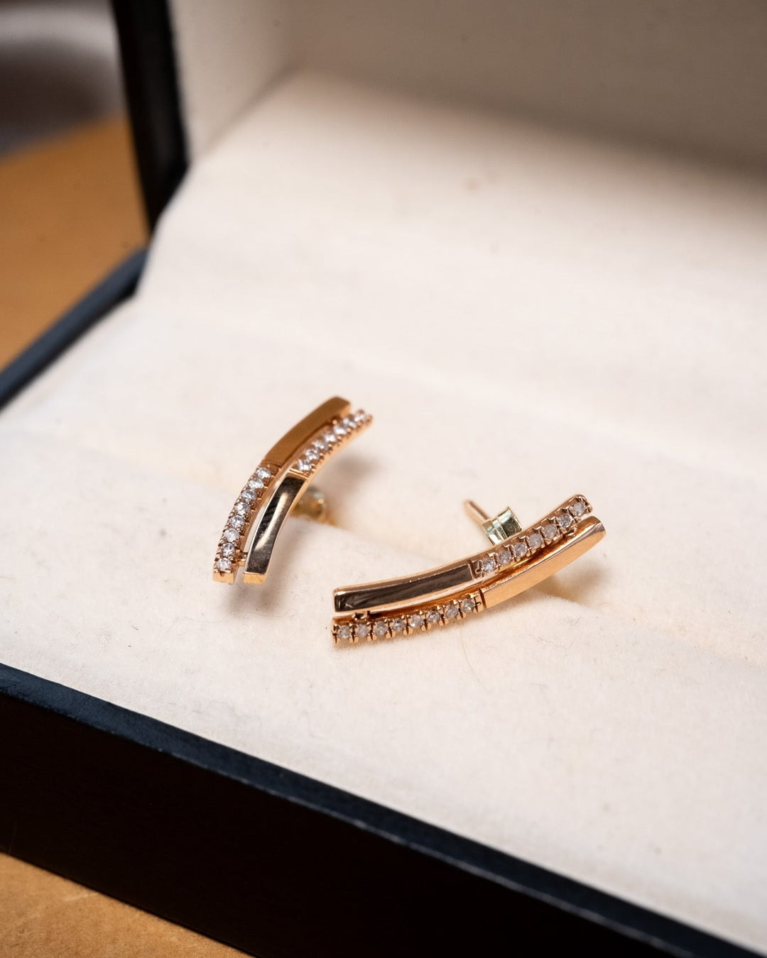 Brincos de ouro rosê com diamantes brilhantes.