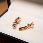 Brincos de ouro rosê com diamantes brilhantes.