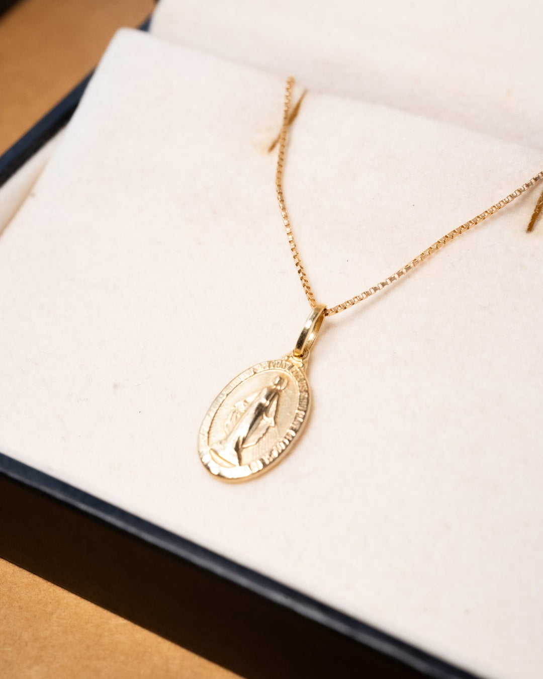 Pingente medalha de Virgem Maria em ouro amarelo. Peso 0.8g. Comprimento 2.0cm e largura 1.0cm.