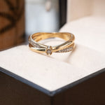 Anel solitário twist monte carlo em ouro amarelo com diamante central de 0.04ct e diamantes laterais de 0.01ct.
