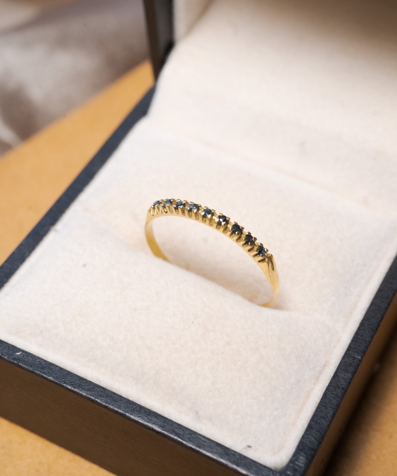Anel meia aliança em ouro amarelo com safiras azuis lapidação brilhante de 1/2 ponto e peso 0.8g.