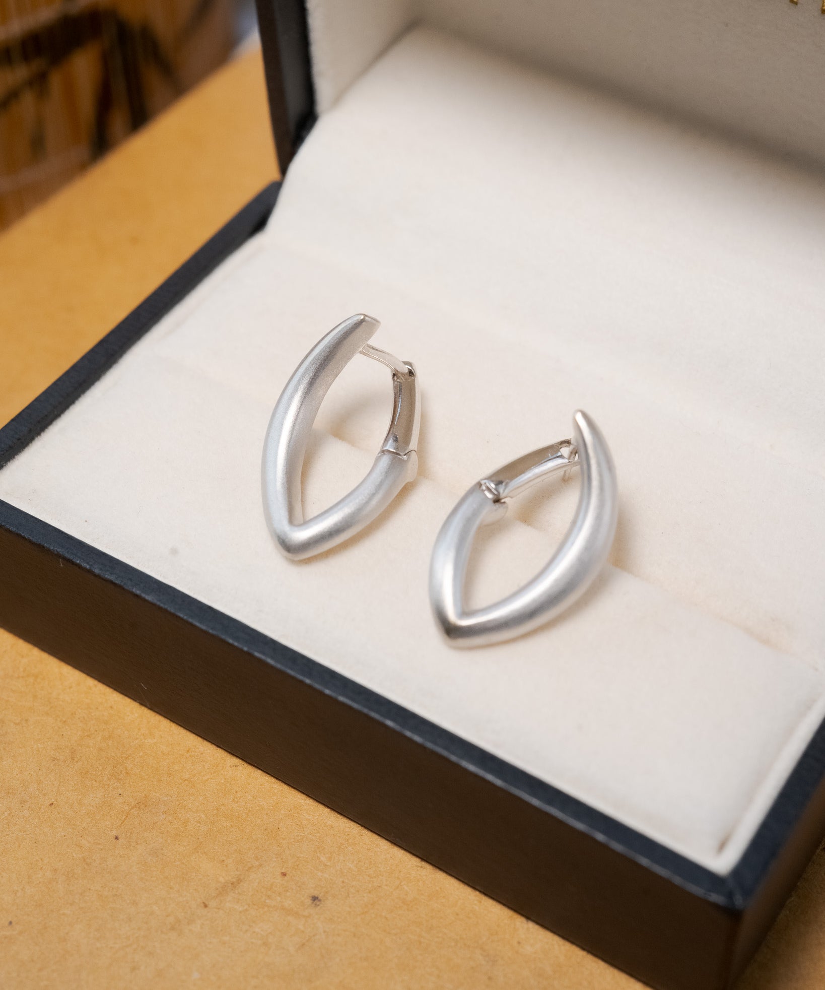 Brinco semi argola geométrica em ouro branco com 2.1cm de comprimento e 1.3cm de largura.