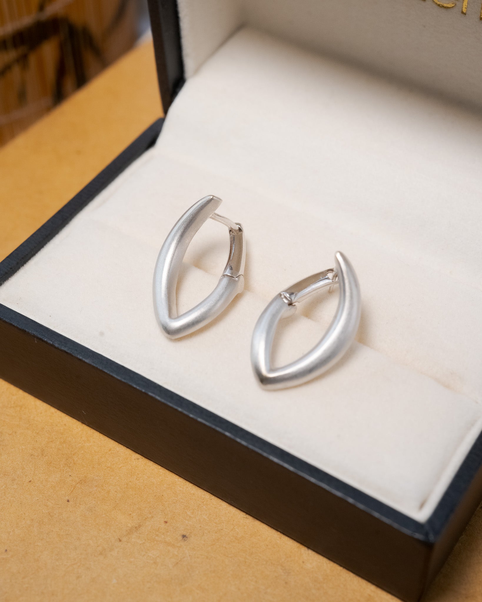 Brinco semi argola geométrica em ouro branco com 2.1cm de comprimento e 1.3cm de largura.