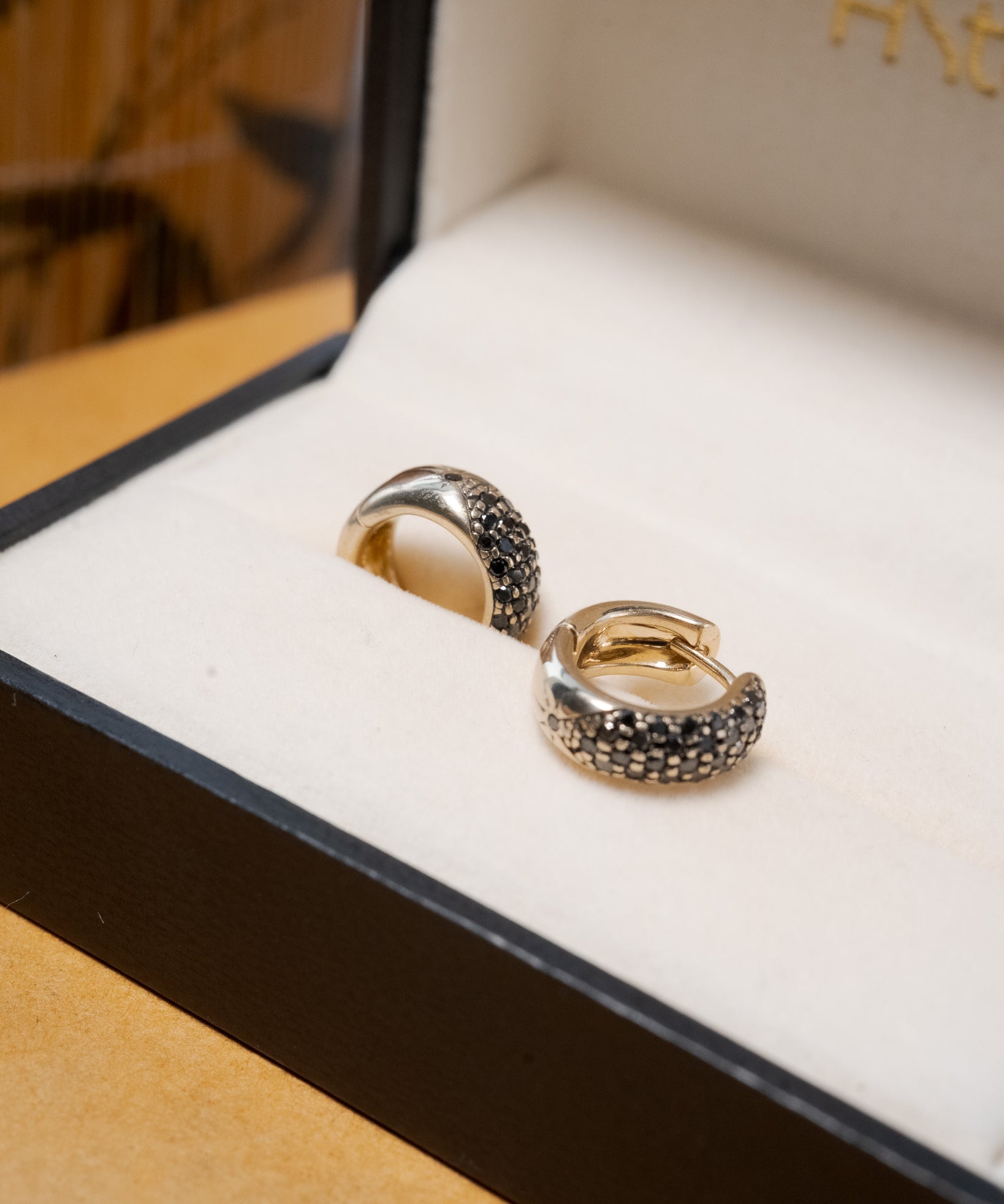 Brinco argola Hstern em ouro nobre com diamantes negros de 1 ponto.
