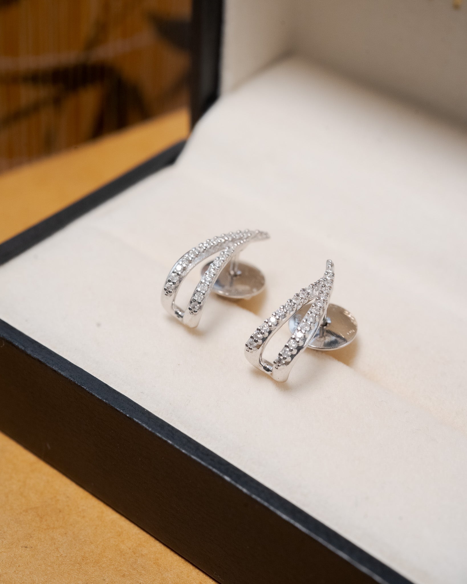 Brinco meia argola Vivara em ouro branco e diamantes lapidação brilhante.