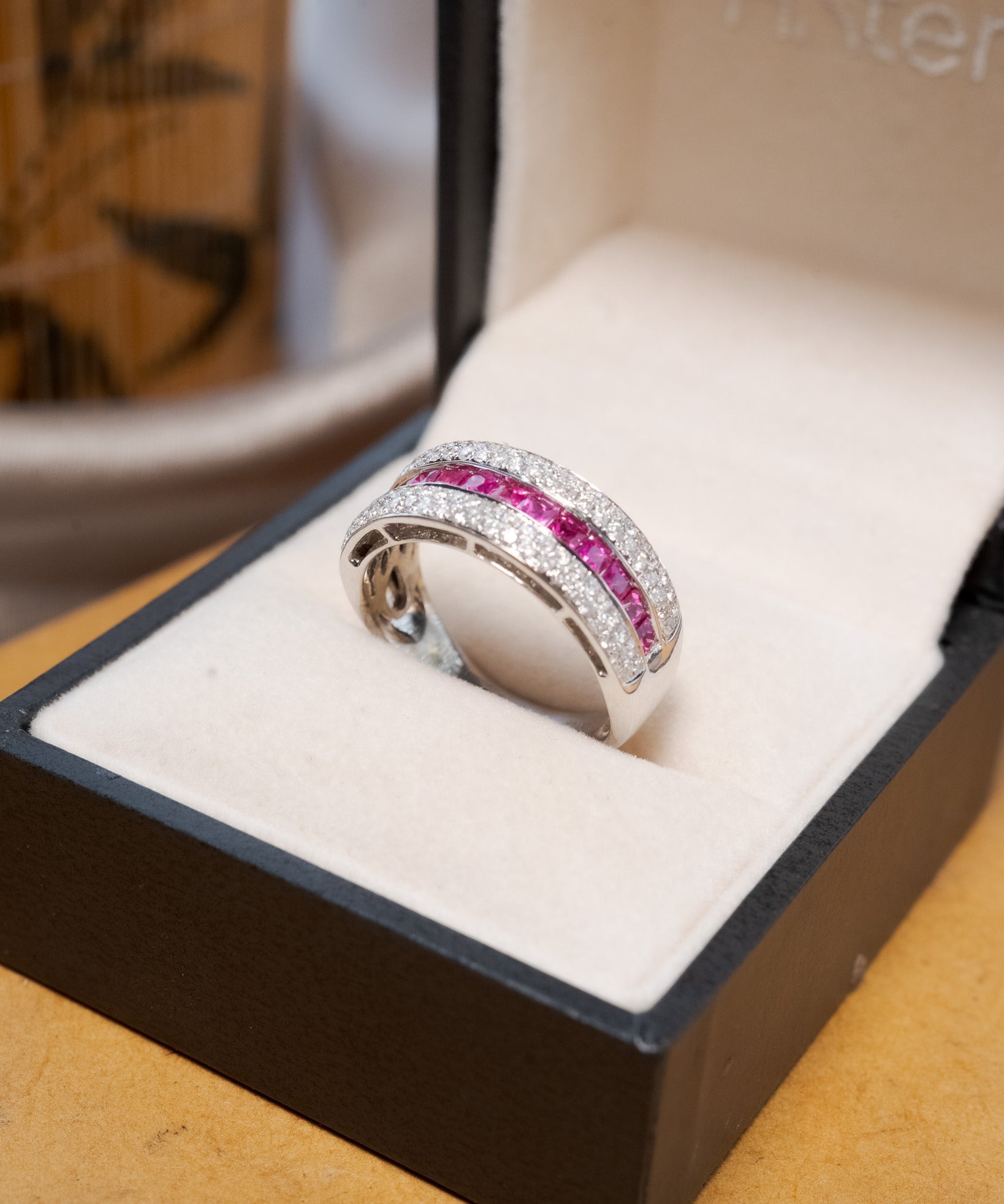 Anel bold pavê em ouro amarelo com diamantes e rubis.