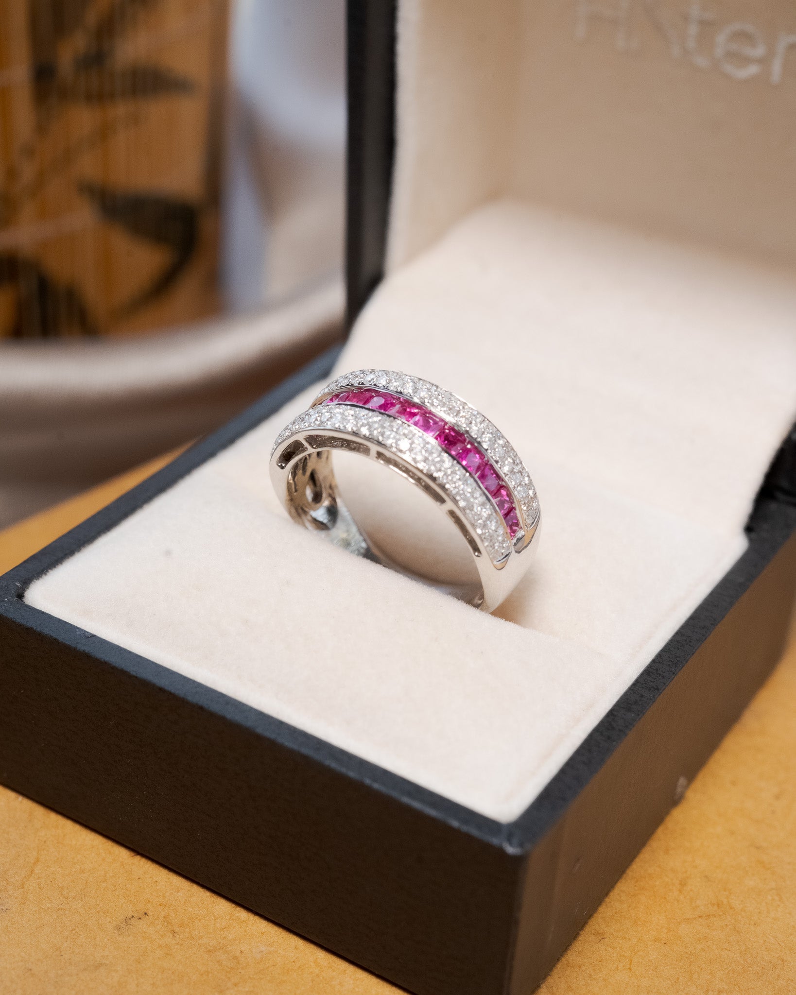 Anel bold pavê em ouro amarelo com diamantes e rubis.