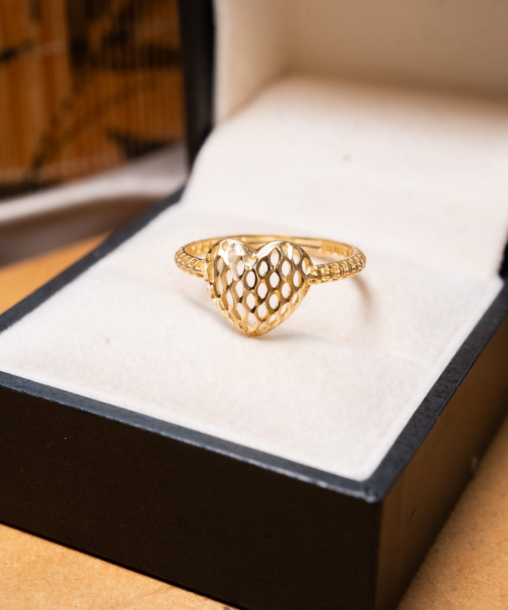Anel em ouro amarelo com design de coração e trama. Aro 18.