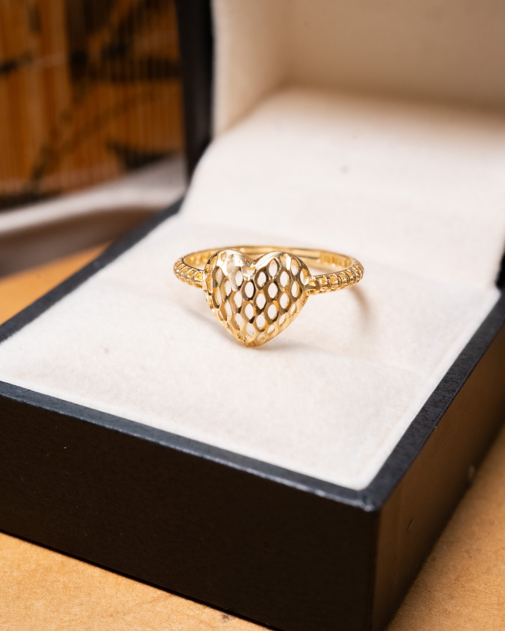 Anel em ouro amarelo com design de coração e trama. Aro 18.