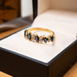 Anel meia aliança em ouro amarelo com safiras azuis e diamantes brancos.