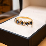Anel meia aliança em ouro amarelo com safiras azuis e diamantes brancos.