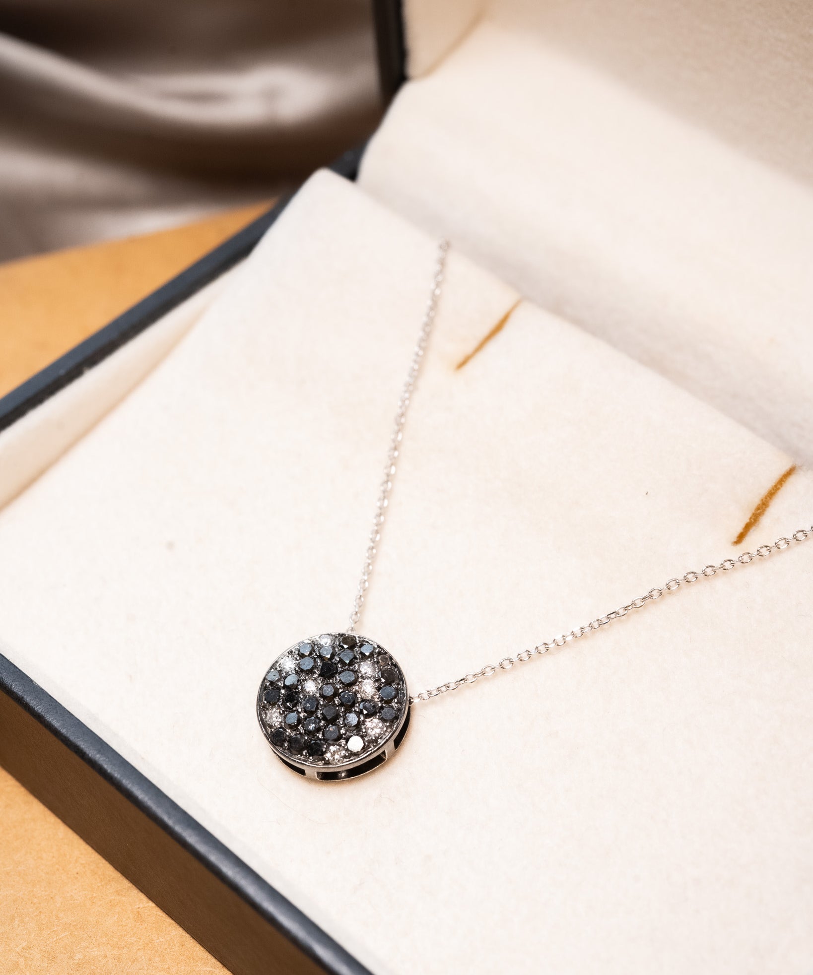 Colar boton em ouro branco com diamantes brancos e negros.