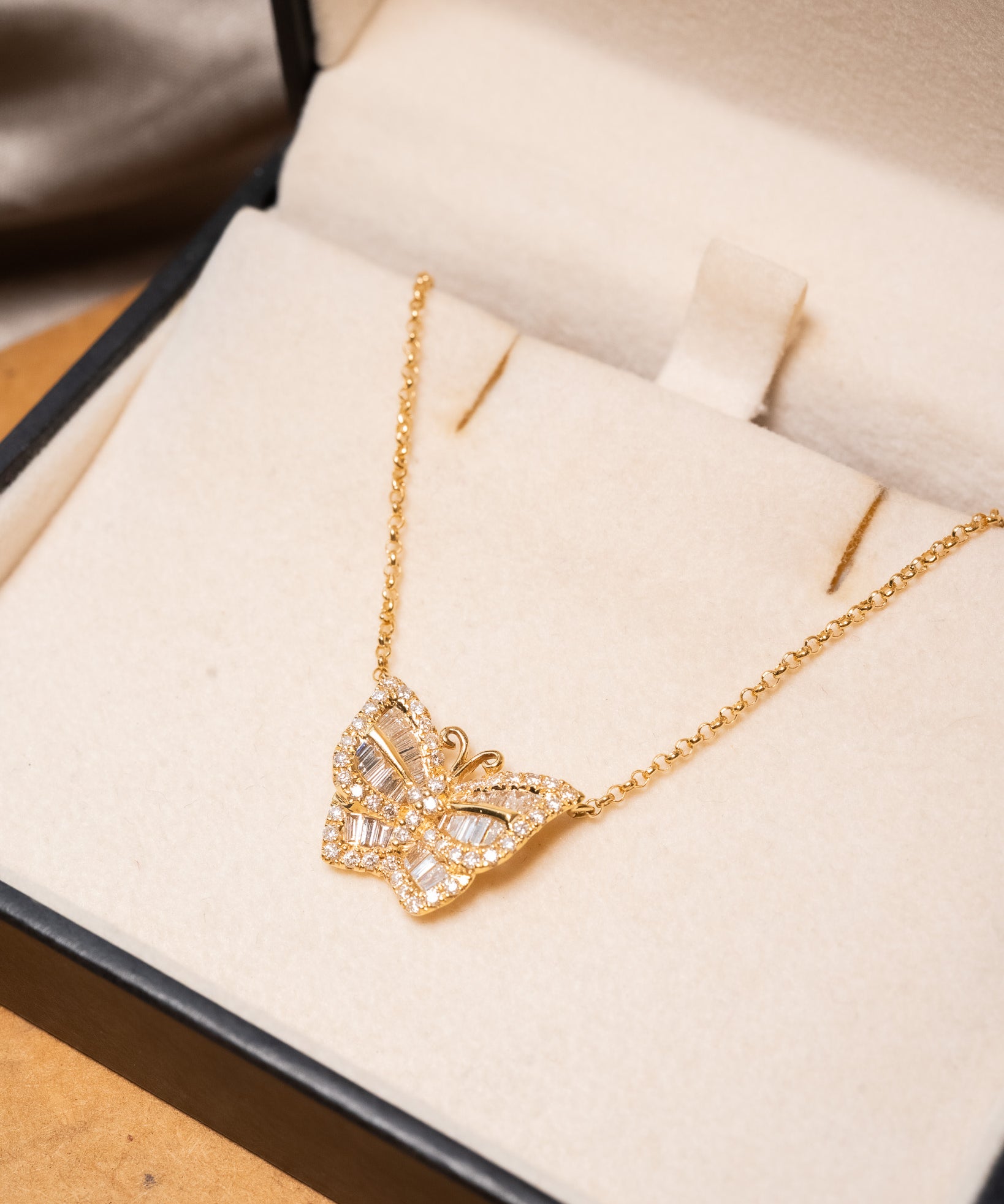 Colar borboleta em ouro amarelo com diamantes brilhantes e baguete.