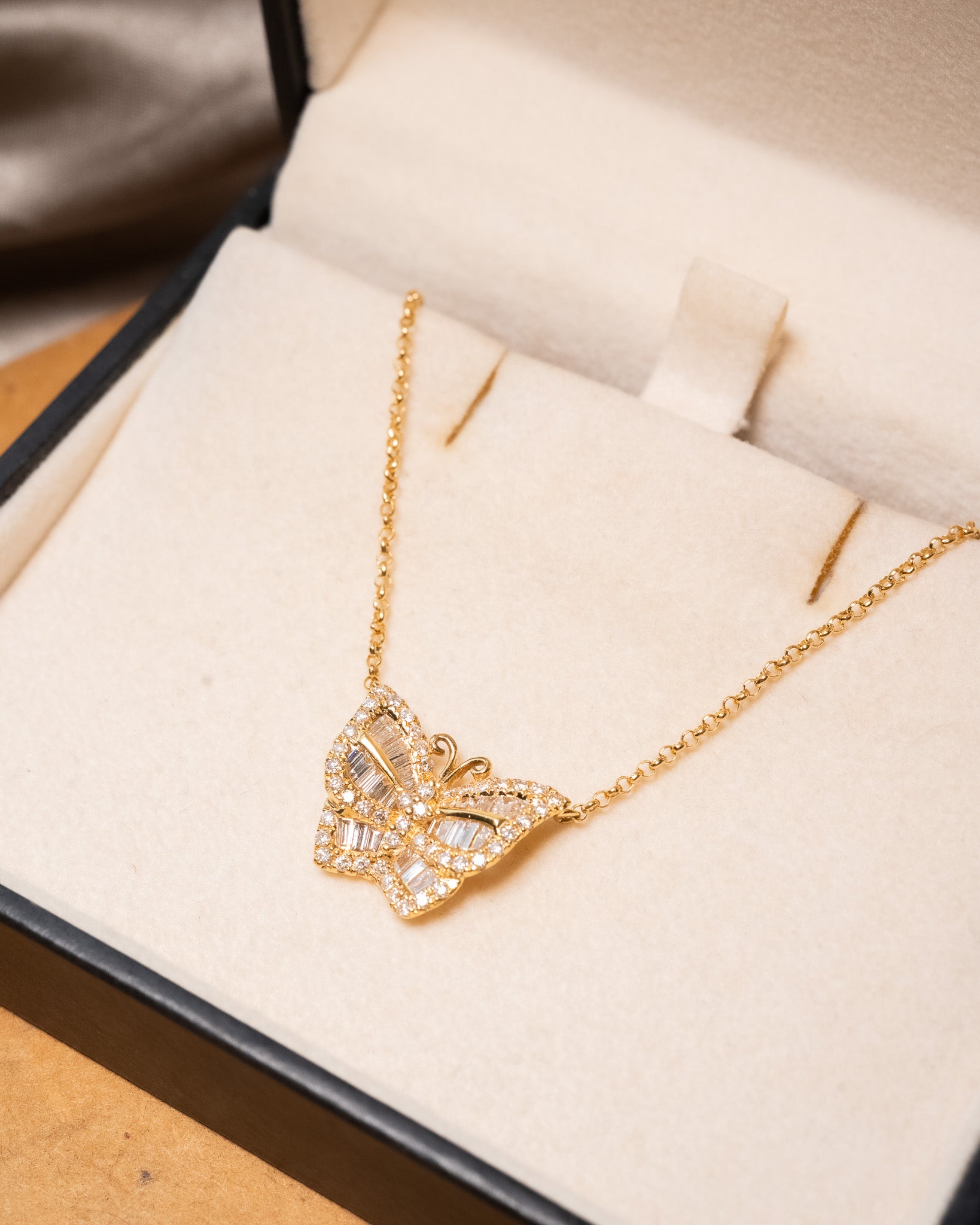 Colar borboleta em ouro amarelo com diamantes brilhantes e baguete.
