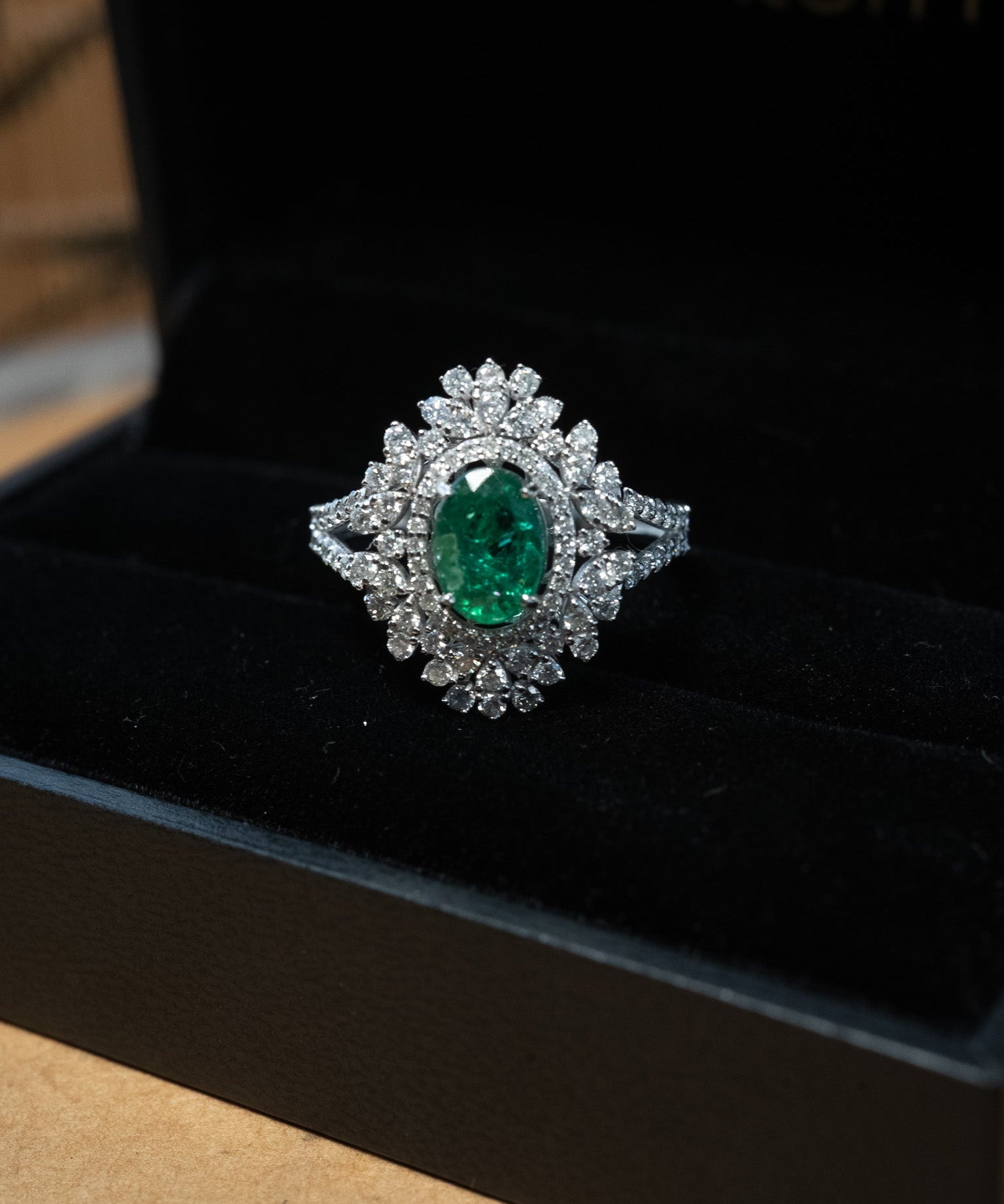 Anel em ouro branco com esmeralda oval de 1.0 quilate e 94 diamantes brilhantes totalizando 1.49 quilates.