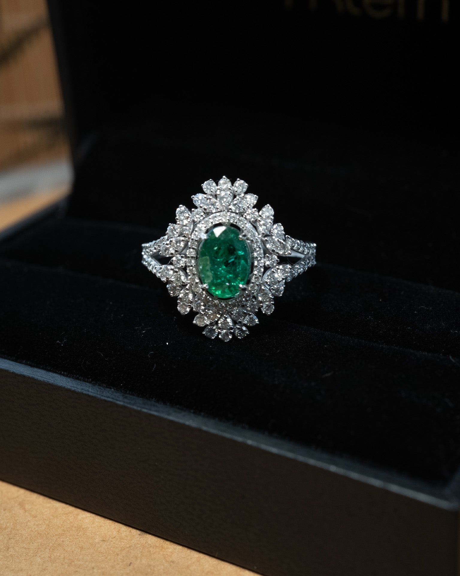 Anel em ouro branco com esmeralda oval de 1.0 quilate e 94 diamantes brilhantes totalizando 1.49 quilates.