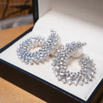 Brincos espiral em ouro branco com 164 diamantes brilhante e baguete totalizando 6.76 quilates e 3.2cm de comprimento.