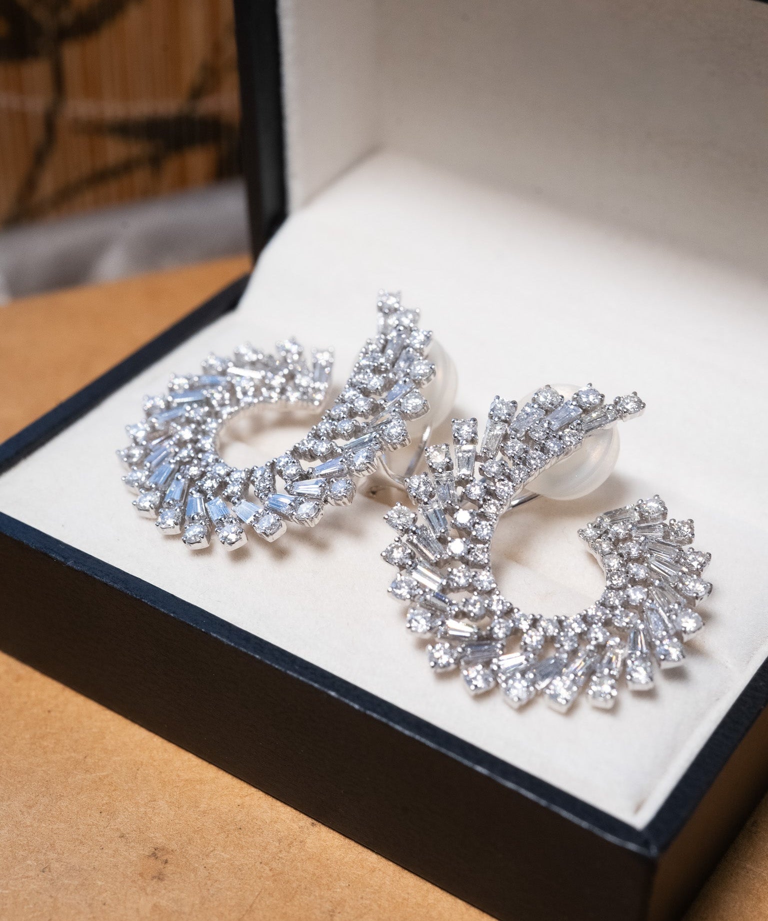 Brincos espiral em ouro branco com 164 diamantes brilhante e baguete totalizando 6.76 quilates e 3.2cm de comprimento.