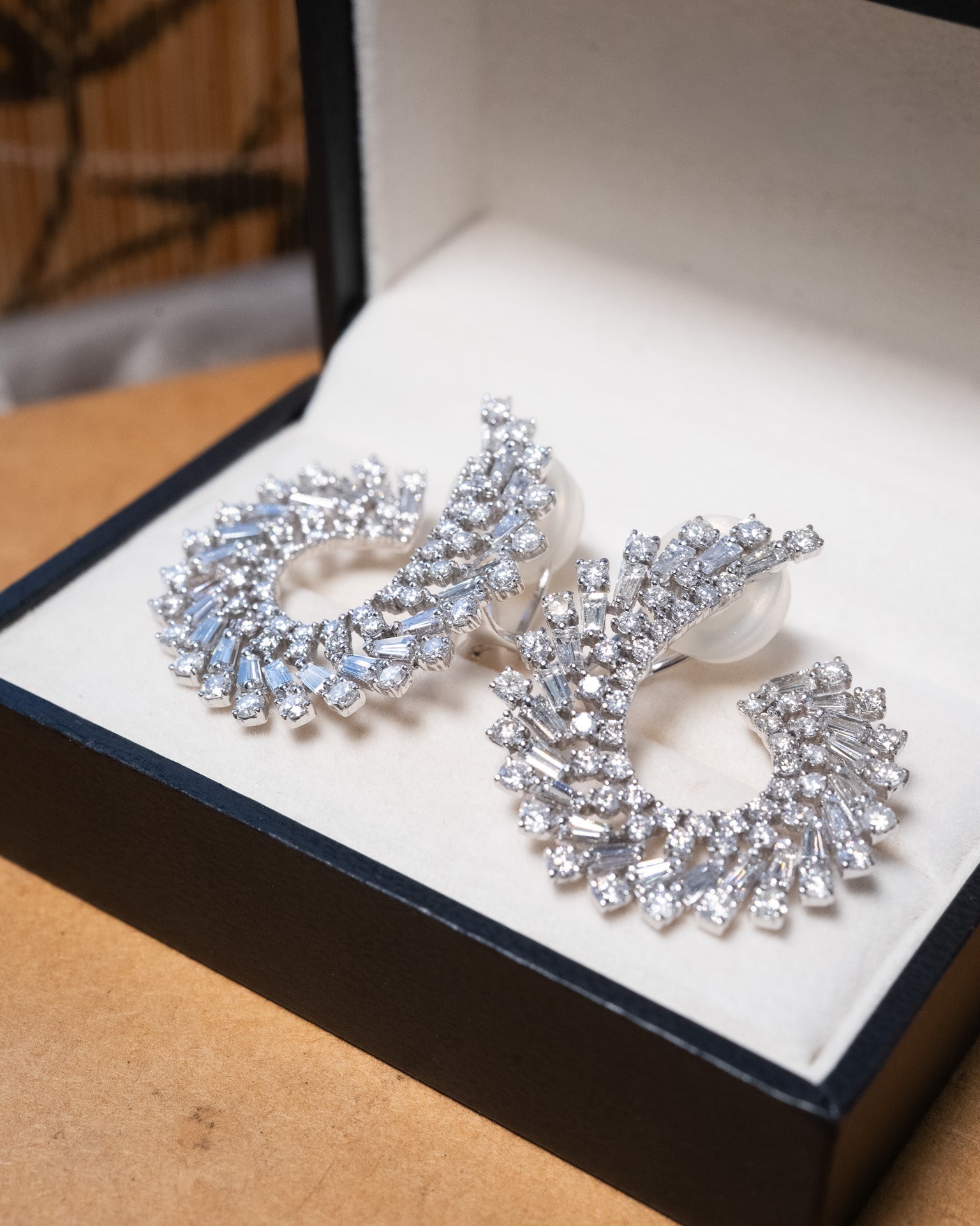 Brincos espiral em ouro branco com 164 diamantes brilhante e baguete totalizando 6.76 quilates e 3.2cm de comprimento.