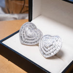 Brincos coração bold em ouro branco com 336 diamantes brilhantes e 130 diamantes baguete totalizando 6.52 quilates.