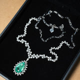 Colar meia riviera em ouro branco com uma esmeralda gota de 2.8ct e 143 diamantes brilhantes totalizando 3.31ct