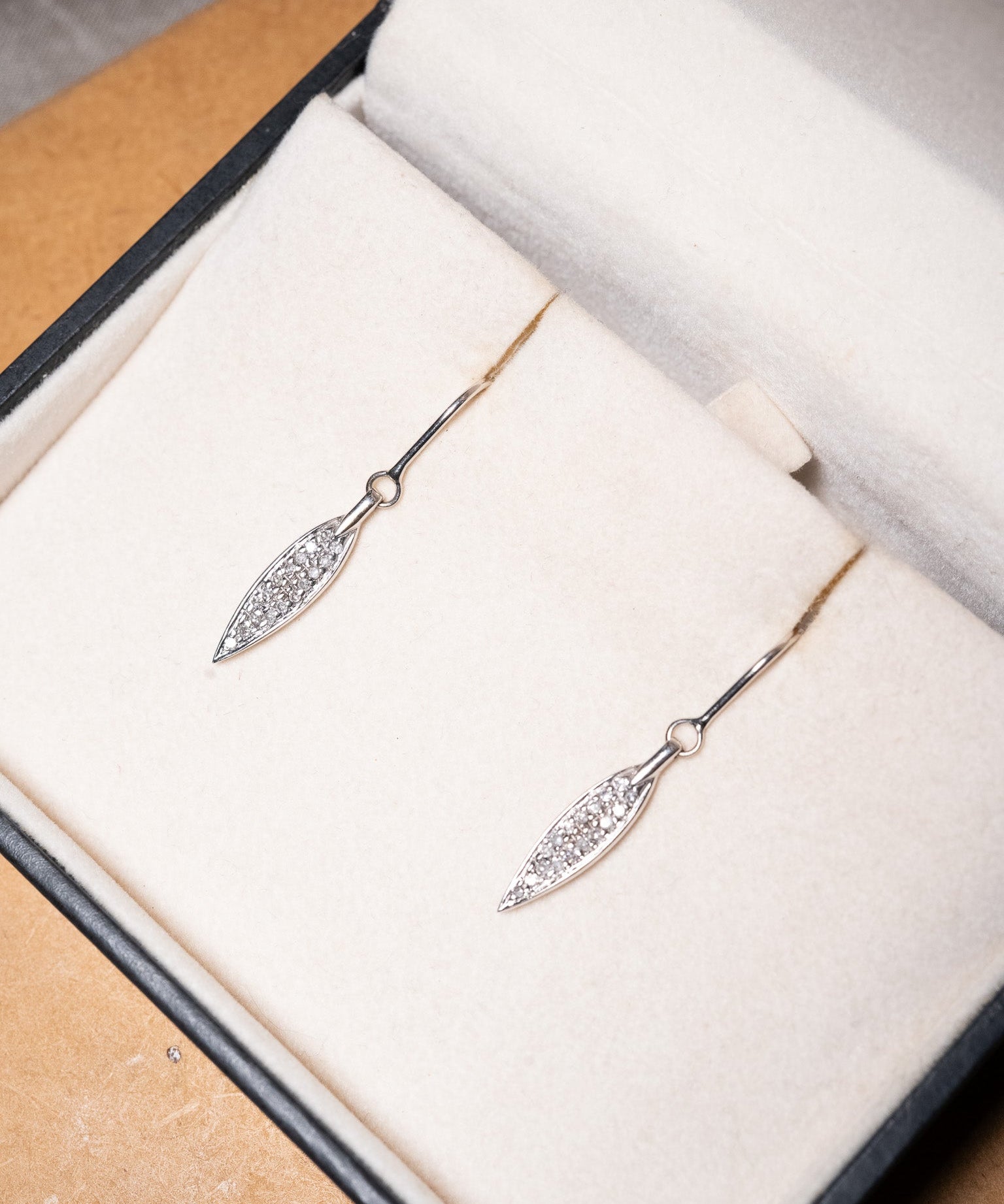 Brinco anzol Vivara em ouro branco com penas e diamantes. Mede 3.0cm de comprimento e 0.4cm de largura e pesa 2.1g