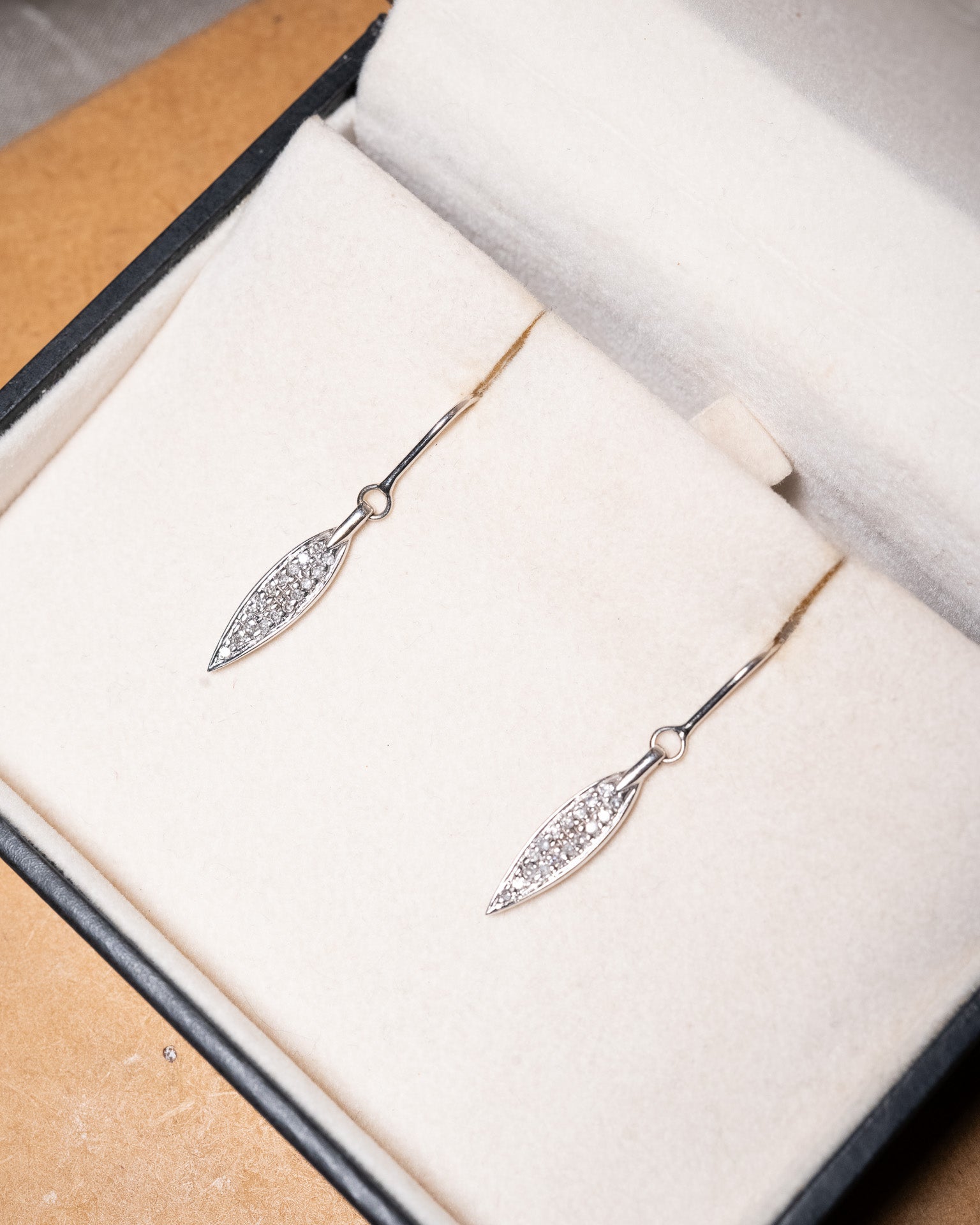 Brinco anzol Vivara em ouro branco com penas e diamantes. Mede 3.0cm de comprimento e 0.4cm de largura e pesa 2.1g