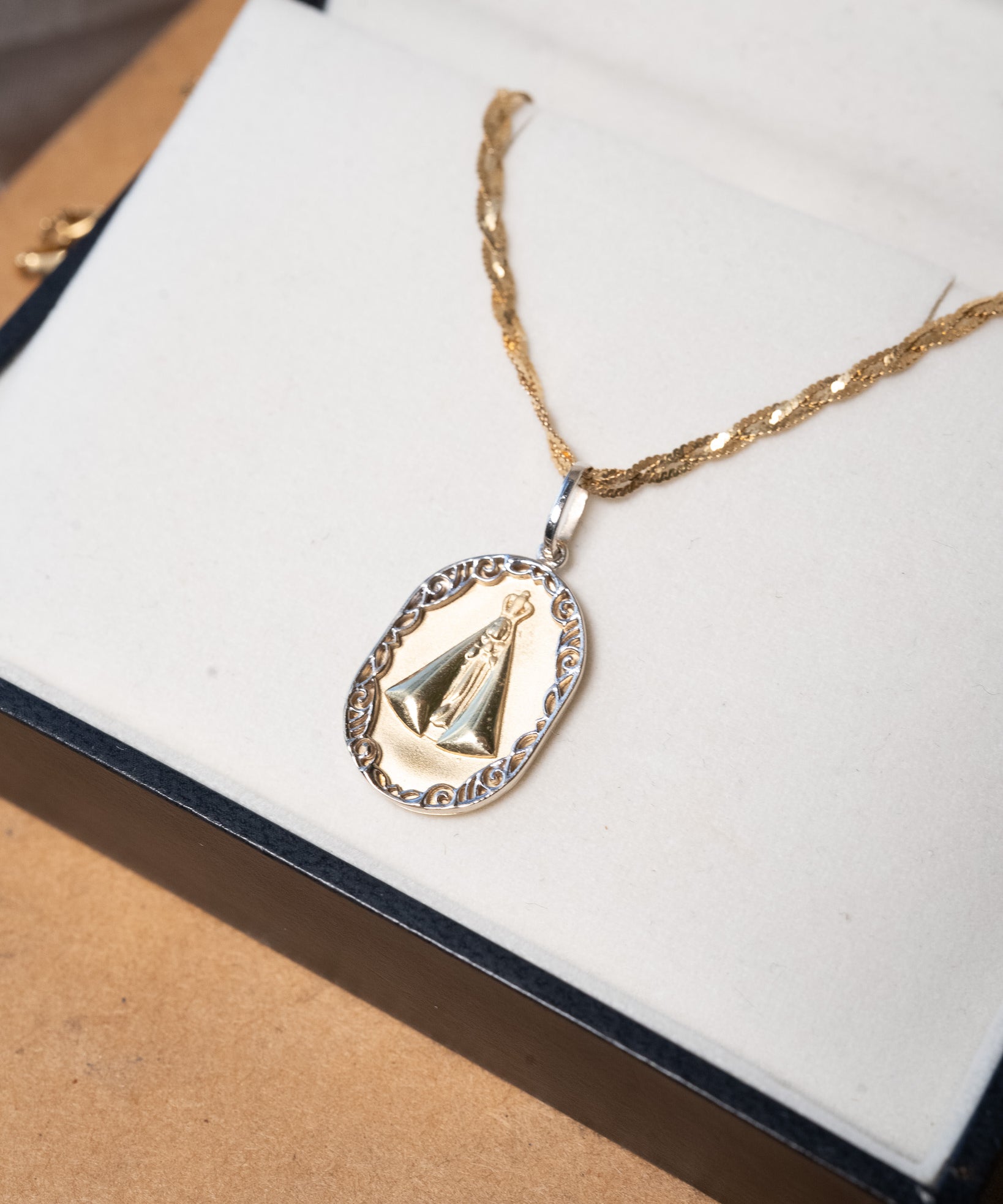 Pingente de Nossa Senhora Aparecida em ouro amarelo e branco com 3.0g 2.8cm de comprimento e 1.0cm de largura.