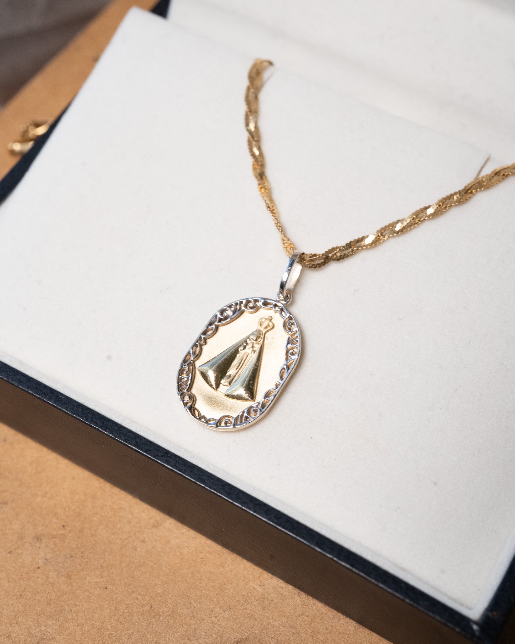 Pingente de Nossa Senhora Aparecida em ouro amarelo e branco com 3.0g 2.8cm de comprimento e 1.0cm de largura.